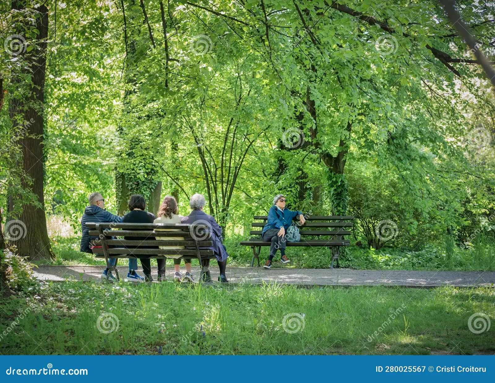 Residents relaxing on park benches surrounded by lush green trees — community life at Porchaven™